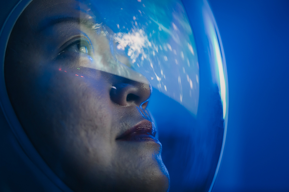 Visage d'une femme à travers un casque de pilote qui regarder au loin
